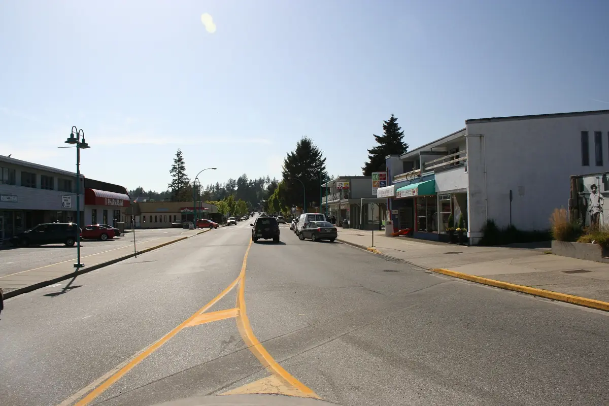 Die Cowrie Street im Zentrum von Sechelt mit niedrigen Geschäften, parkenden Autos und gelber Mittellinie