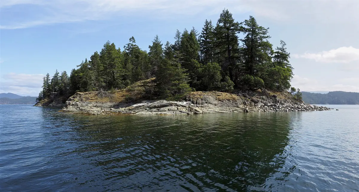 Kleine bewaldete Insel mit felsigem Ufer im Desolation Sound
