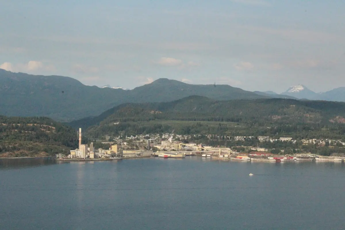 Powell River vom Wasser aus gesehen, mit Fabrikgebäuden und Bergen dahinter