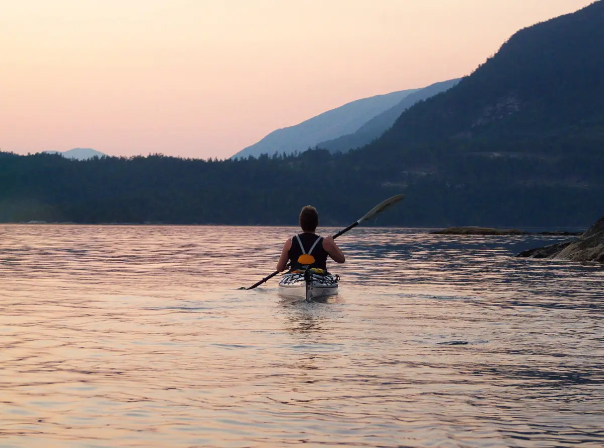 Paddler als Silhouette auf dem ruhigen Sechelt Inlet im rosa Abendlicht