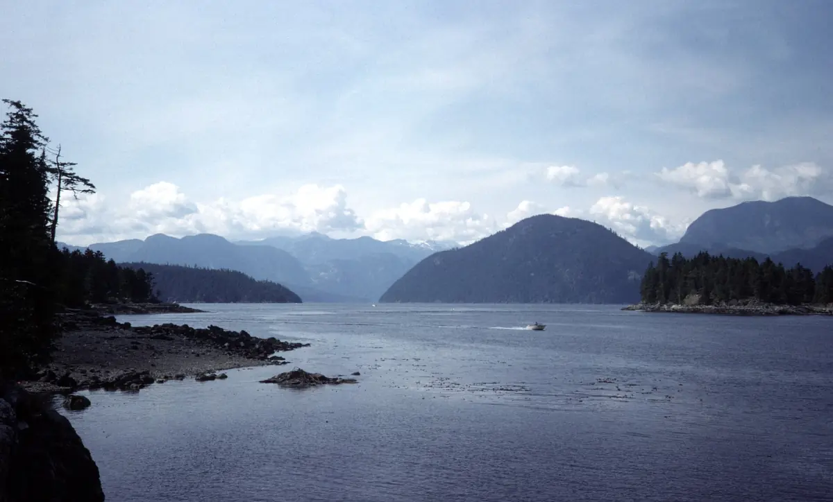 Historischer Blick von 1974 über das Sechelt Inlet auf blaue Bergketten und bewölkten Himmel