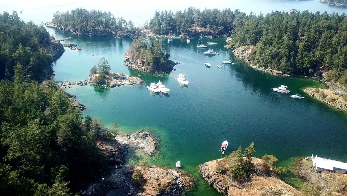 Luftbild der türkisfarbenen Smuggler Cove mit Booten zwischen bewaldeten Inselchen
